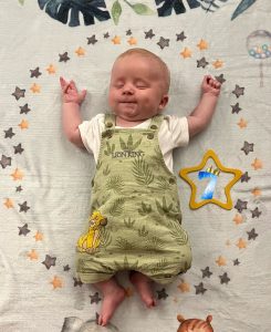 A baby boy lying on his back.